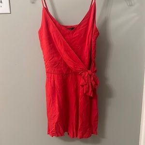 Red romper with spaghetti straps and a bow in front.